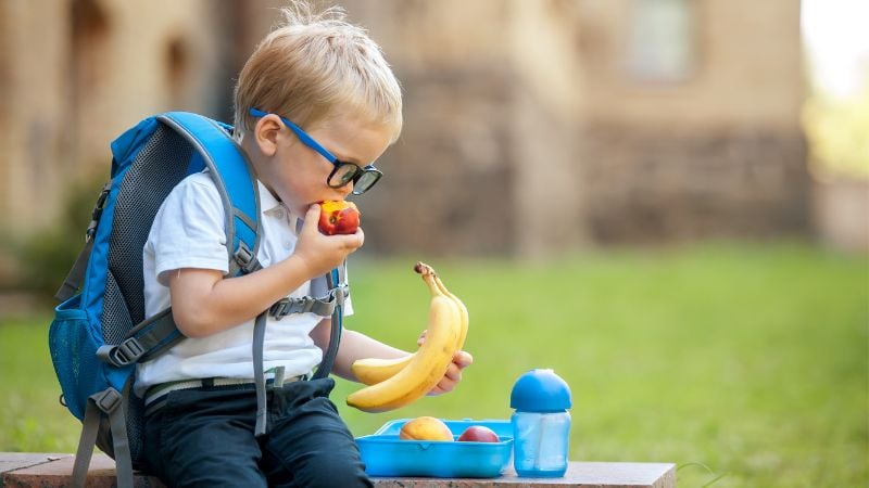 student eating lunch with backpack