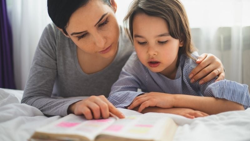 mother and daughter studying bible