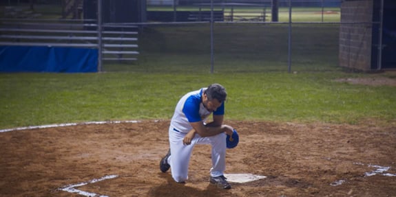 coach praying at home base in running the bases