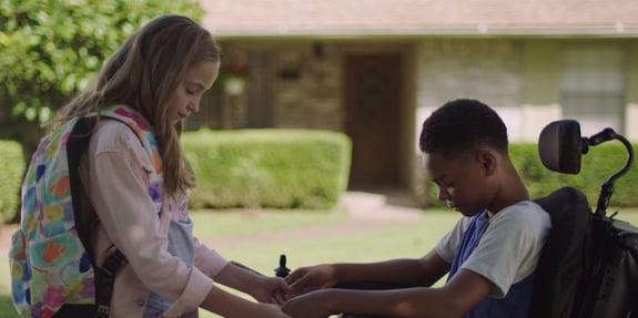 little girl holding hands with classmate praying
