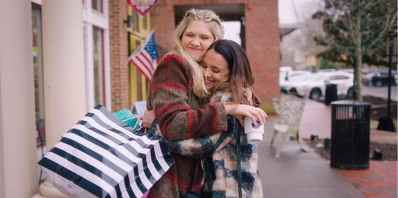 divine influencer hugging with shopping bags