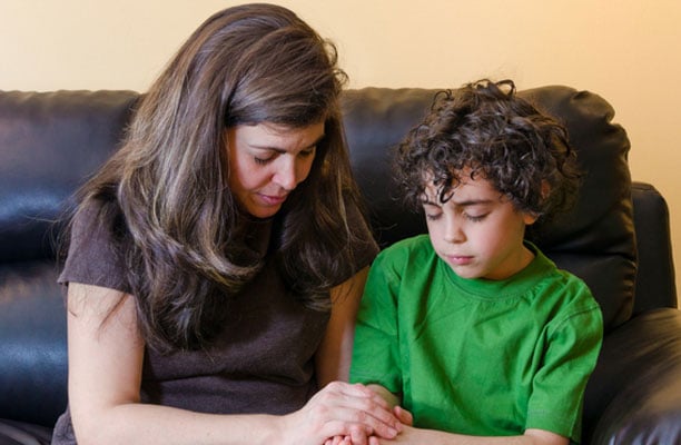 mother and son praying for Gods protection and safekeeping